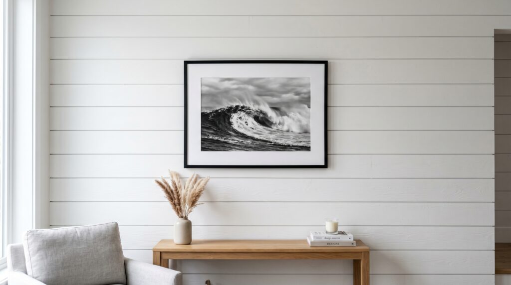 Minimalist coastal black and white ocean wave art print framed on a white shiplap wall.